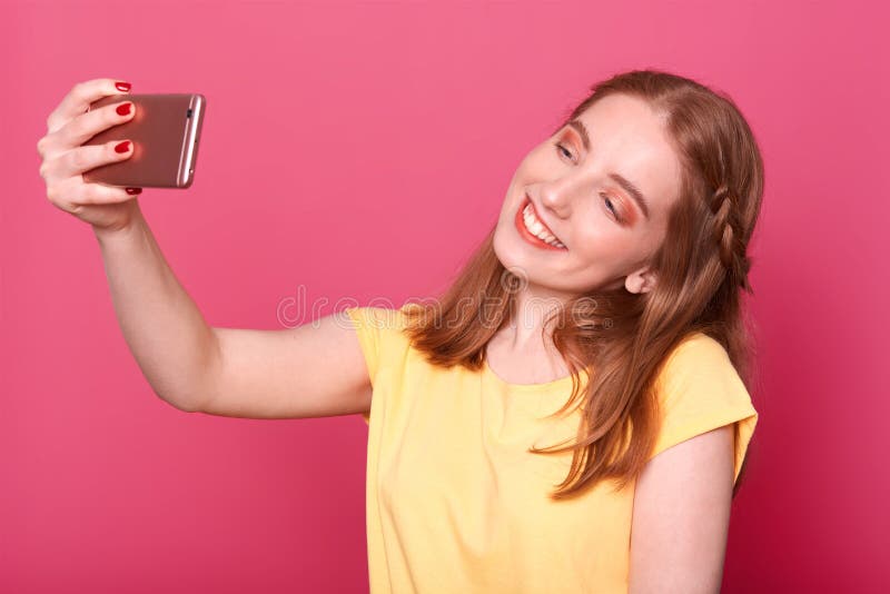 做selfie的年轻美丽的时髦的妇女接近的画象,使用她自己的智能手机,微笑在照相机,穿戴了偶然 库存照片 做selfie的年轻美丽的时髦的妇女接近的画象,使用她自己的智能手机,微笑在照相机,穿戴了偶然 库存照片
