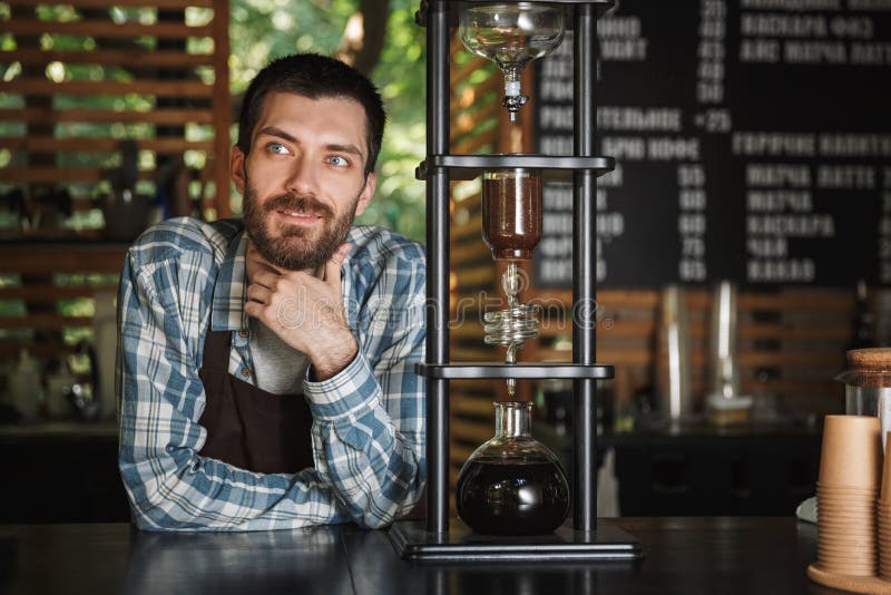 做咖啡的爽快barista男孩的图象,当工作在室外时的咖啡馆或的咖啡馆 免版税图库摄影