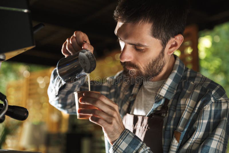 做咖啡的男性barista人的图象,当工作在室外时的咖啡馆或的咖啡馆 库存照片