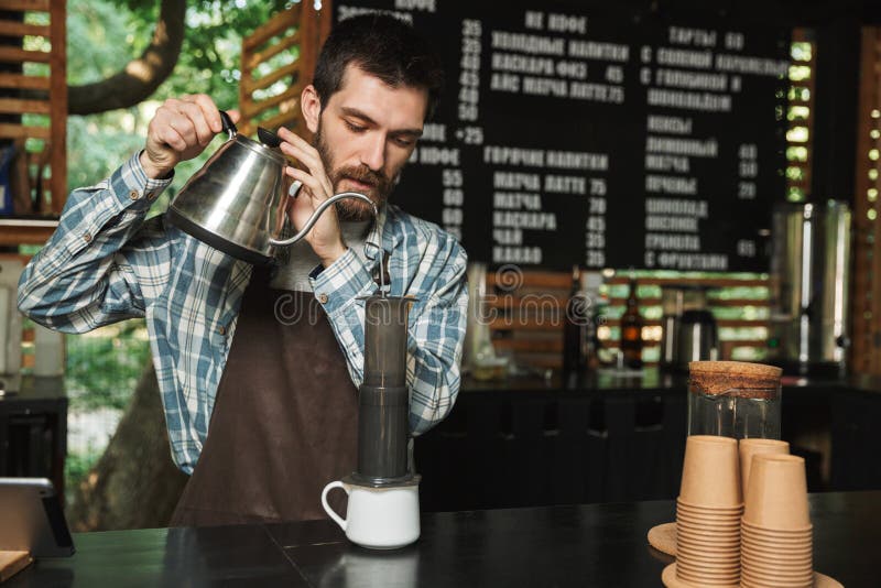做咖啡的白种人barista人画象,当工作在室外时街道的咖啡馆或的咖啡馆 免版税库存图片