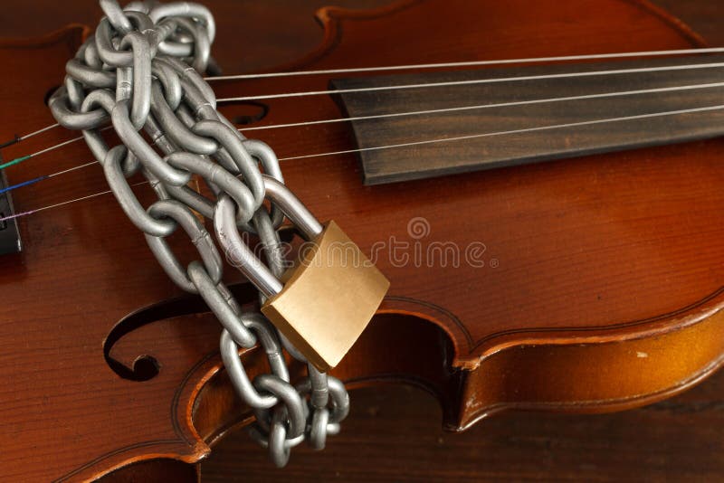 Soul of the music stopped concept: classical violin locked with chain. Soul of the music stopped concept: classical violin locked with chain