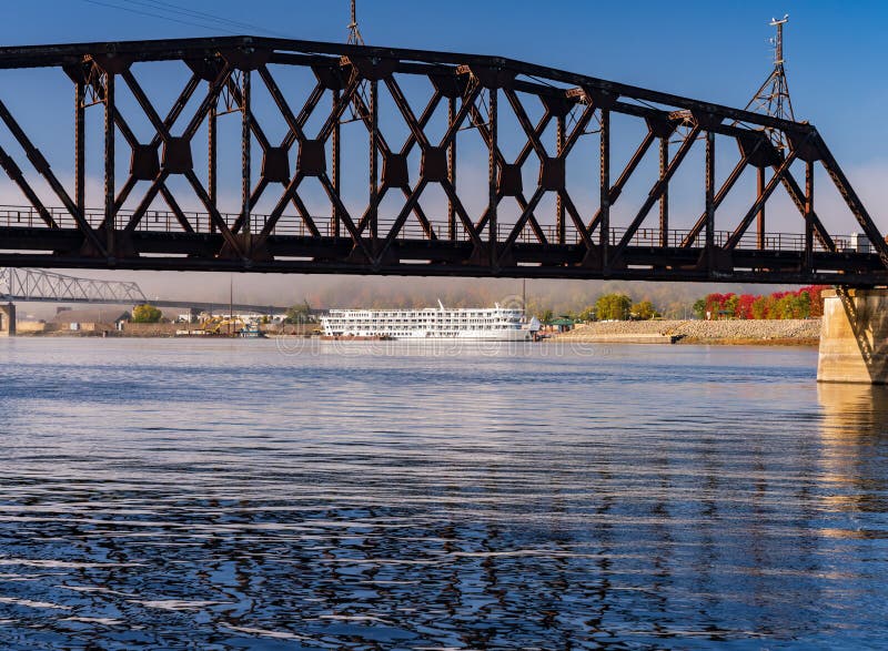 Dubuque Railroad bridge across Upper Mississippi on calm misty morning with docked river cruise boat. Dubuque Railroad bridge across Upper Mississippi on calm misty morning with docked river cruise boat