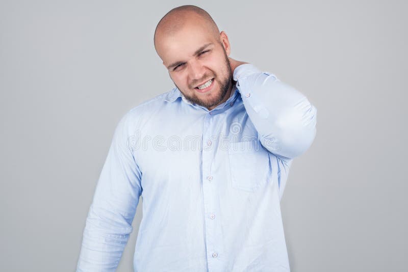 健康问题概念 被挫败的年轻白种人人有脖子痛,与哀伤的表示的神色,穿白色衬衫,需要按摩 图库摄影 健康问题概念 被挫败的年轻白种人人有脖子痛,与哀伤的表示的神色,穿白色衬衫,需要按摩 图库摄影