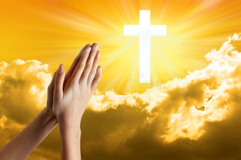 A young girls hands praying with a cross in a sky background. A young girls hands praying with a cross in a sky background