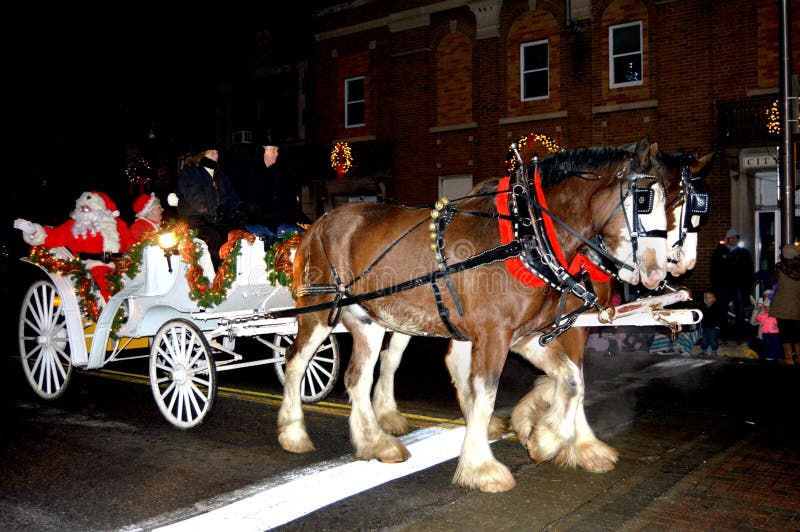 Santa Claus and Mrs. Claus riding down the streets of Burlington, Wisconsin in a carriage pulled by horses at the Burlington Christmas Parade. Santa Claus and Mrs. Claus riding down the streets of Burlington, Wisconsin in a carriage pulled by horses at the Burlington Christmas Parade.