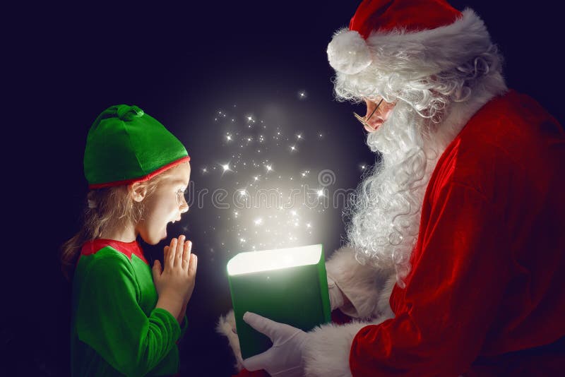 Cute little girl and Santa Claus opening a magic gift box. Cute little girl and Santa Claus opening a magic gift box.