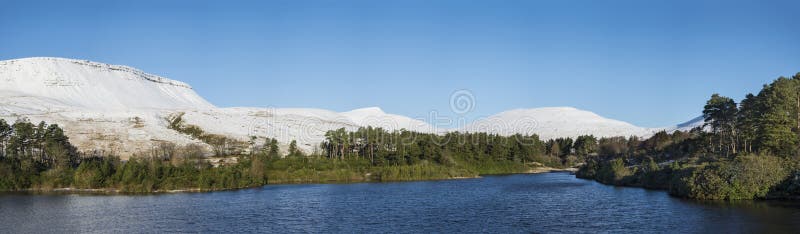 全景湖冬天风景有森林和山脉的 免版税图库摄影