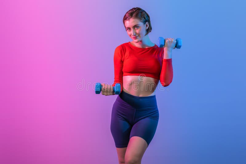 Full body length gaiety shot athletic and sporty woman with dumbbell for weight lifting as bodybuilding exercise in standing posture on isolated background. Healthy active and body care lifestyle. Full body length gaiety shot athletic and sporty woman with dumbbell for weight lifting as bodybuilding exercise in standing posture on isolated background. Healthy active and body care lifestyle