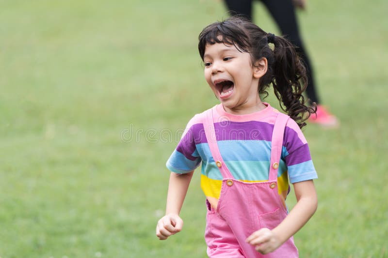 公园中白人女孩的肖像,在大自然中玩乐. 轻快笑着跑的小女孩 免版税库存照片
