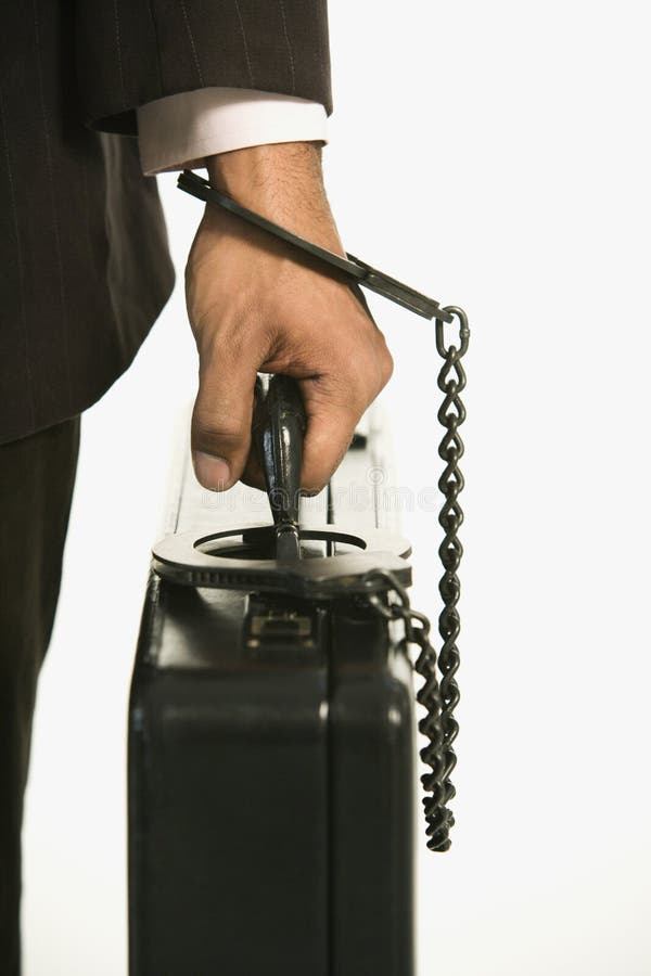 African American businessman in suit handcuffed to briefcase. African American businessman in suit handcuffed to briefcase.