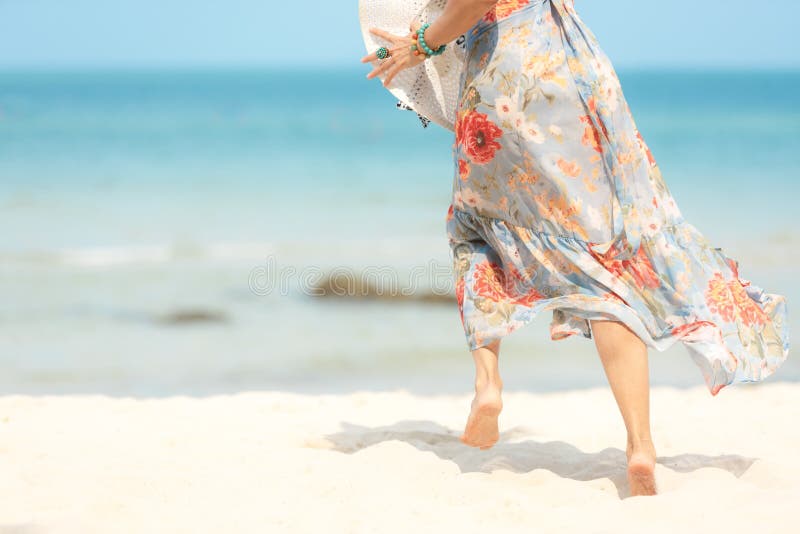 关闭跑在含沙海洋海滩的腿微笑的生活方式妇女佩带的时尚礼服夏天 愉快的妇女享用并且放松 图库摄影 关闭跑在含沙海洋海滩的腿微笑的生活方式妇女佩带的时尚礼服夏天 愉快的妇女享用并且放松 图库摄影