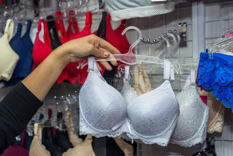 Woman choosing white bra in underwear shop. Woman choosing white bra in underwear shop.