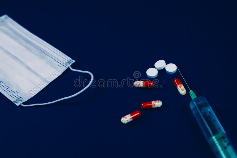 冠状病毒的药丸和呼吸面罩 面部防护面膜、药丸和药丸,用蓝色疫苗注射 免版税库存图片 冠状病毒的药丸和呼吸面罩 面部防护面膜、药丸和药丸,用蓝色疫苗注射 免版税库存图片