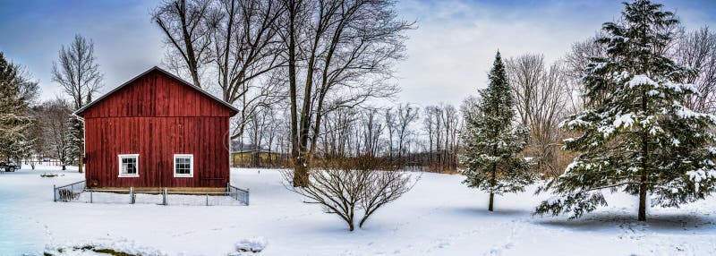 A snowy winter scene with a red barn and pine trees. A snowy winter scene with a red barn and pine trees.