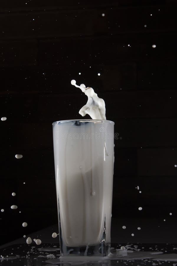 冷牛奶在玻璃杯中溅起水花 免版税库存照片 冷牛奶在玻璃杯中溅起水花 免版税库存照片