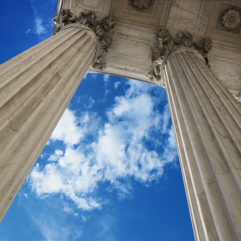 Low angle view looking up at blue sky with clouds and columns of Supreme Court building in Washington D.C. Low angle view looking up at blue sky with clouds and columns of Supreme Court building in Washington D.C.