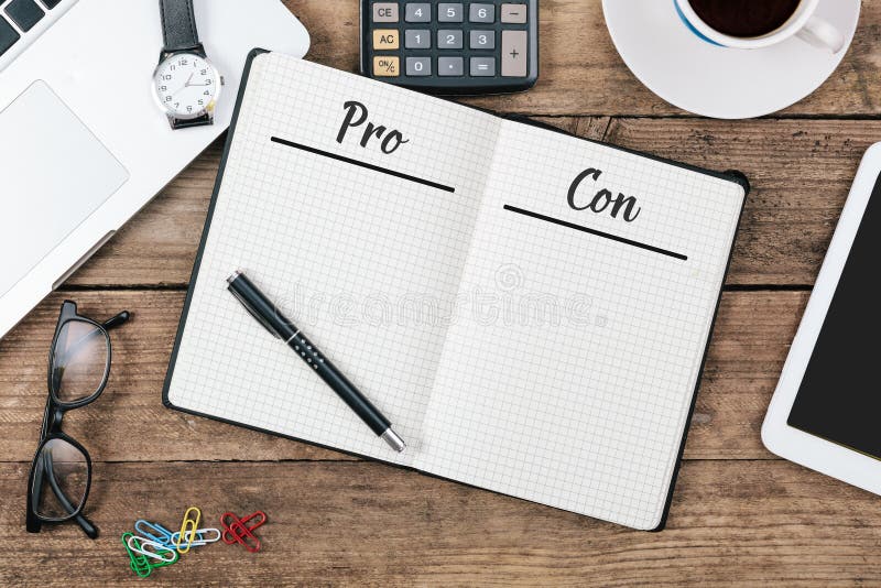 Pro and Con pages written in note pad on wooden office technology desk flat lay. Pro and Con pages written in note pad on wooden office technology desk flat lay