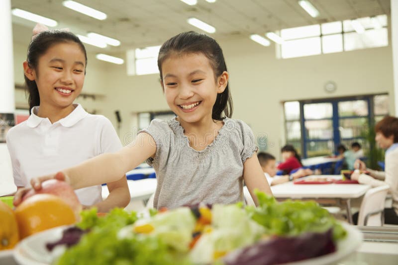 Students reaching for healthy food in school cafeteria. Students reaching for healthy food in school cafeteria