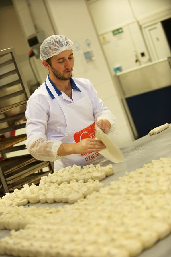 ISTANBUL, TURKEY - AUGUST 10: Turkish chef making unbaked cookies in the baker factory on August 10, 2017 in Istanbul, Turkey. ISTANBUL, TURKEY - AUGUST 10: Turkish chef making unbaked cookies in the baker factory on August 10, 2017 in Istanbul, Turkey.