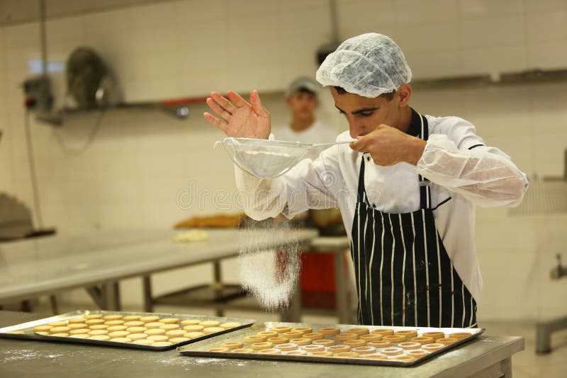 ISTANBUL, TURKEY - AUGUST 10: Turkish chef making unbaked cookies in the baker factory on August 10, 2017 in Istanbul, Turkey. ISTANBUL, TURKEY - AUGUST 10: Turkish chef making unbaked cookies in the baker factory on August 10, 2017 in Istanbul, Turkey.