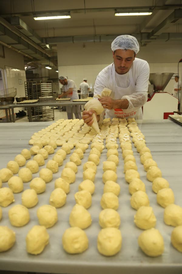 ISTANBUL, TURKEY - AUGUST 10: Turkish chef making unbaked cookies in the baker factory on August 10, 2017 in Istanbul, Turkey. ISTANBUL, TURKEY - AUGUST 10: Turkish chef making unbaked cookies in the baker factory on August 10, 2017 in Istanbul, Turkey.