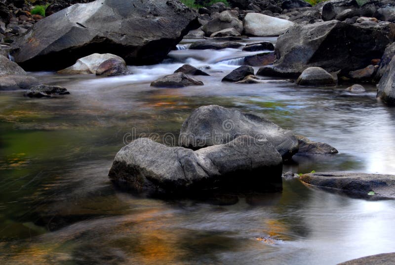 Long exposure of small rapids in the Merced River in California with colorful reflections in the water. Long exposure of small rapids in the Merced River in California with colorful reflections in the water.