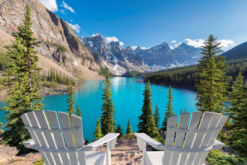 Two chairs at Beautiful turquoise waters of the Moraine lake at sunset in Banff National Park of Canada. Two chairs at Beautiful turquoise waters of the Moraine lake at sunset in Banff National Park of Canada.