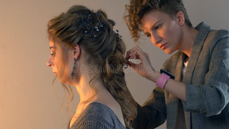 化妆师和美发师在婚礼前准备新娘 有短的时髦的发型的美发师美发师申请构成