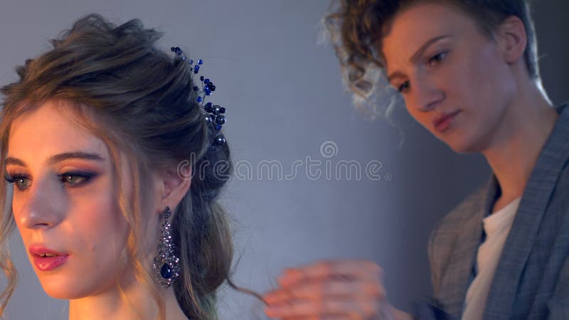 化妆师和美发师在婚礼前准备新娘 有短的时髦的发型的美发师美发师申请构成