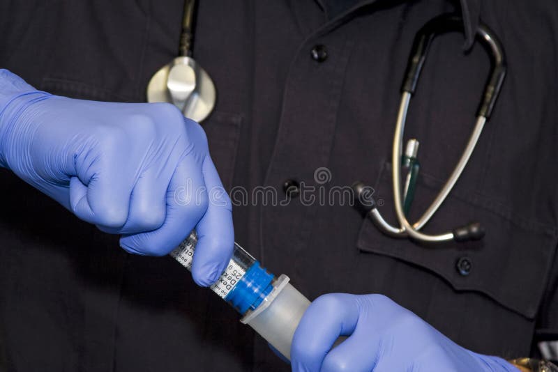 Paramedic putting togather a preloaded medication medication. Paramedic putting togather a preloaded medication medication