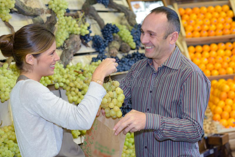 卖绿色葡萄的顾客 图库摄影