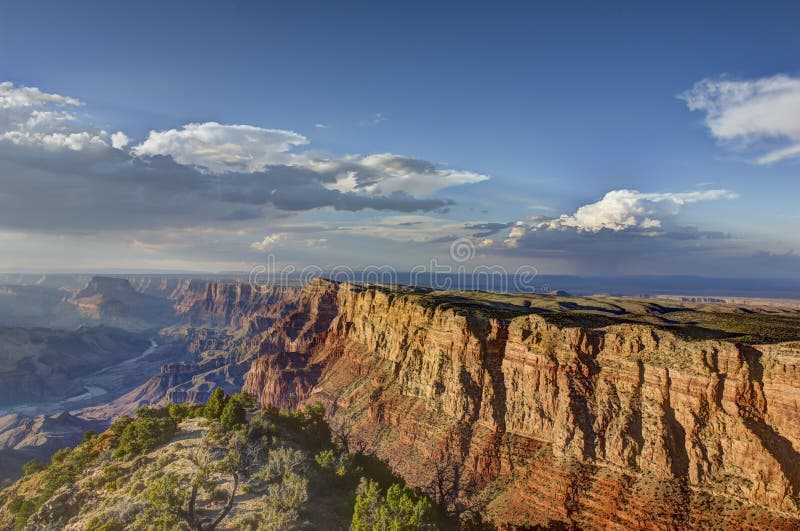 Wide angle image of Grand Canyon South Rim with blue sky and white clouds. Wide angle image of Grand Canyon South Rim with blue sky and white clouds.