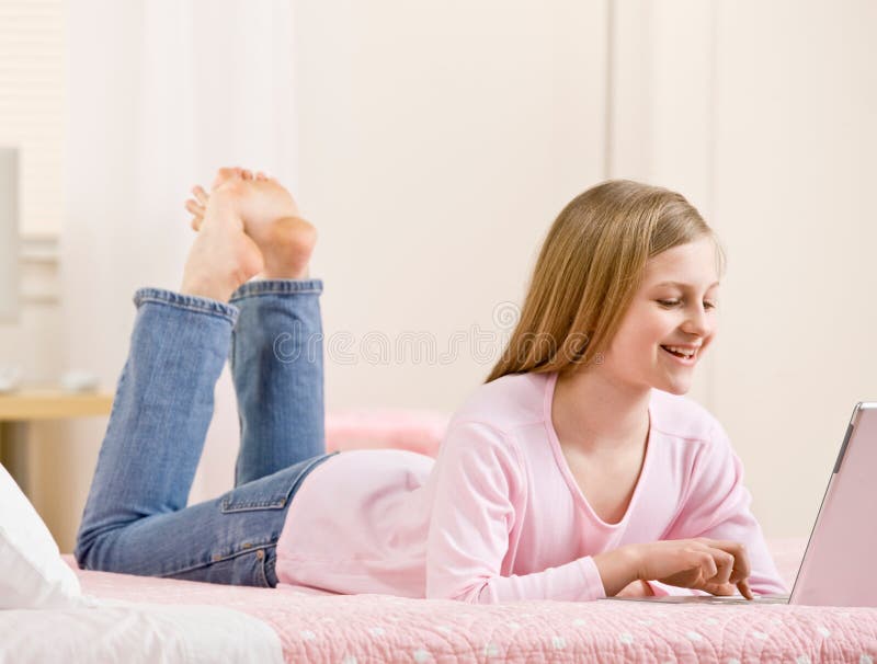 卧室女孩她的互联网膝上型计算机使用