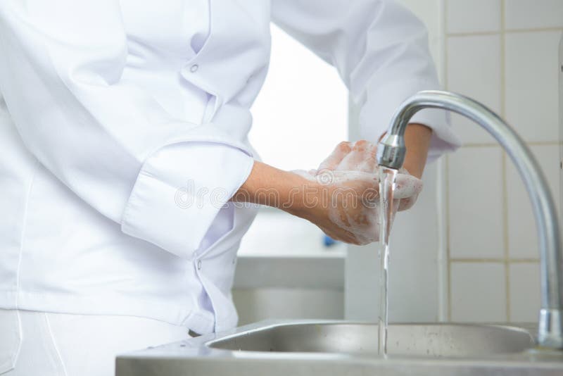 厨师在流水下洗手 库存照片