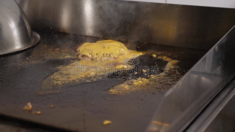 厨师拿出一块带融化奶酪的熟饼,用热炉做汉堡 股票视频