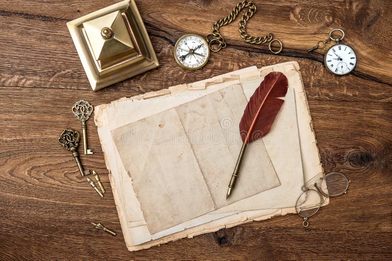 Antique accessories and office supplies on wooden table. vintage keys, clock, glasses, feather pen, compass. nostalgic sentimental background. Antique accessories and office supplies on wooden table. vintage keys, clock, glasses, feather pen, compass. nostalgic sentimental background