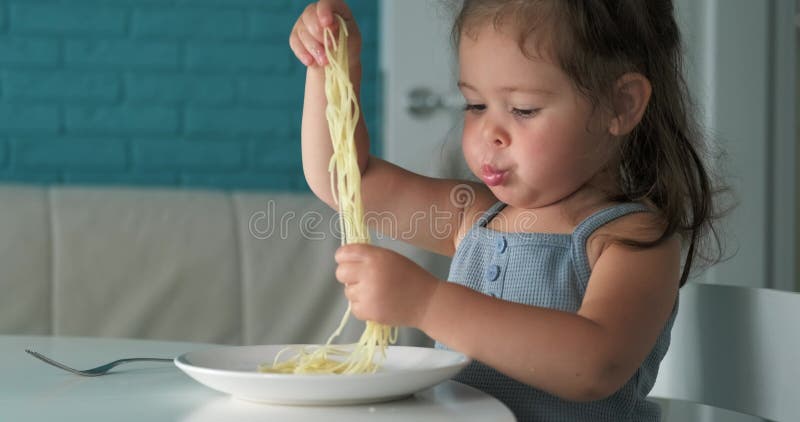 可爱蹒跚学步的女孩吃意大利面面快乐的幼儿园女孩吃着意大利面她用双手把意大利面塞进嘴里 影视素材 - 视频 包括有 杂乱, 白种人: 291109388