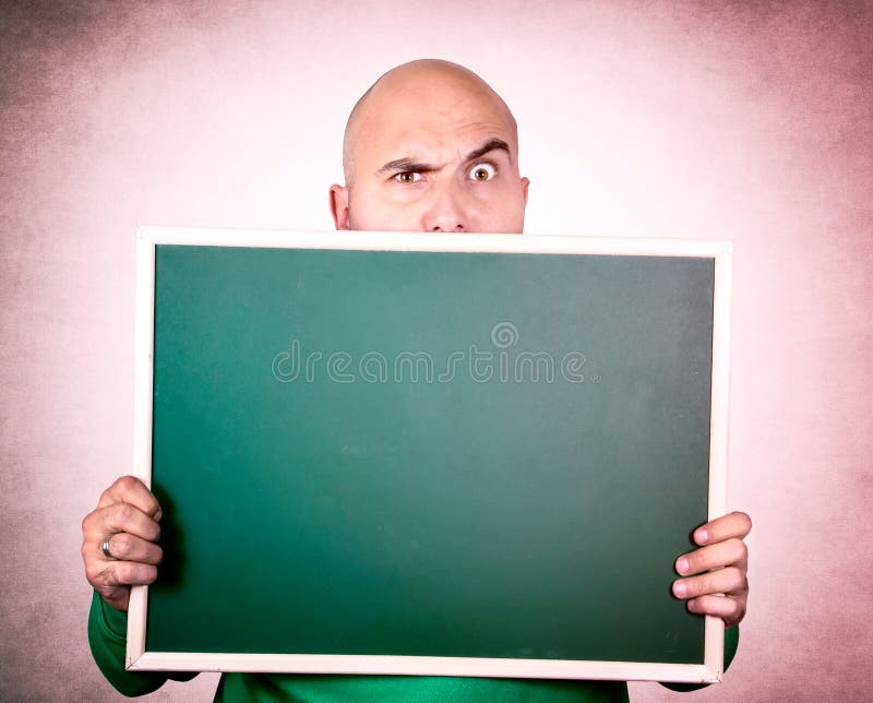 Suspicious bald man holding blank chalk board. Suspicious bald man holding blank chalk board