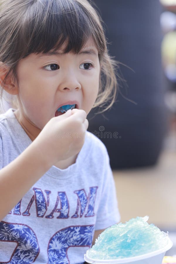 日本女孩在吃刨冰 免版税库存图片