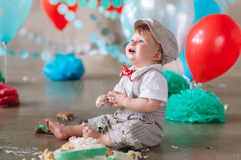 吃蛋糕的杂乱男婴在查寻他的1岁生日 库存照片 吃蛋糕的杂乱男婴在查寻他的1岁生日 库存照片