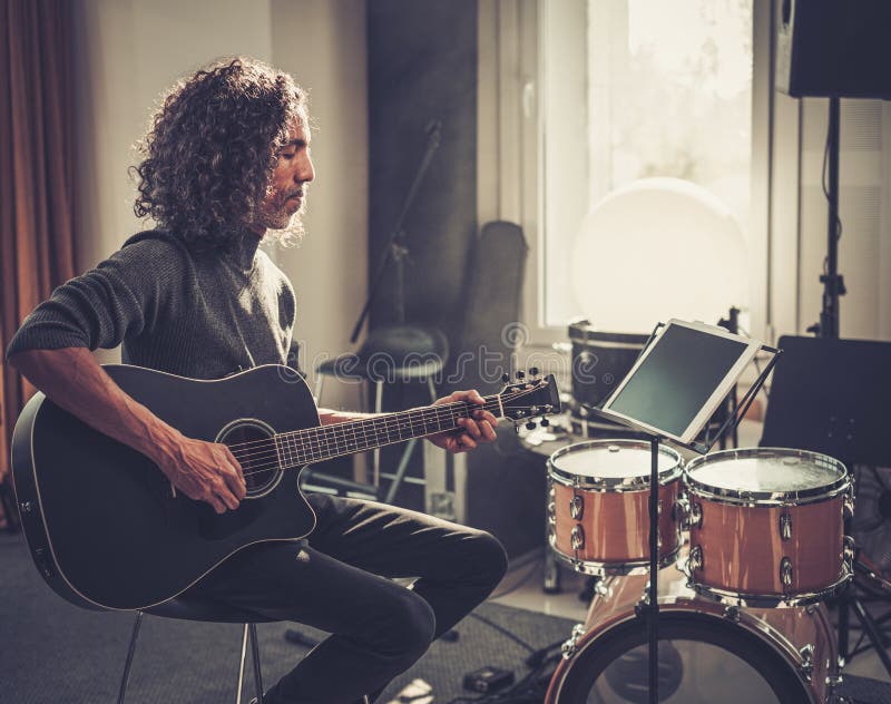 吉他手在平板电脑上弹奏旋律 免版税图库摄影