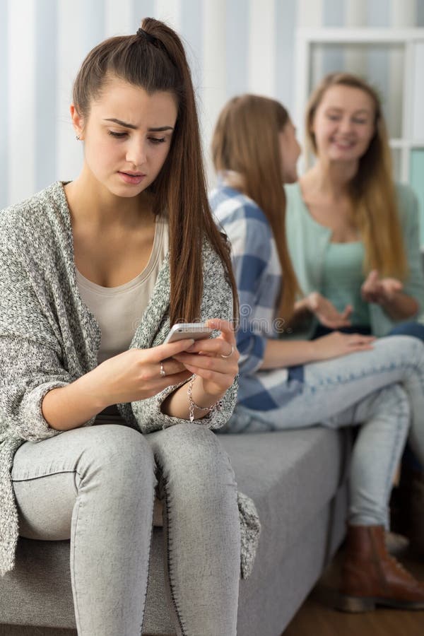 Image of girl with phone stalked by school peer. Image of girl with phone stalked by school peer