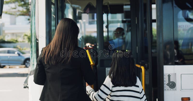 后巴士站和有女孩的母亲出行，早上乘坐公共交通. 家庭城市服务 免版税库存图片