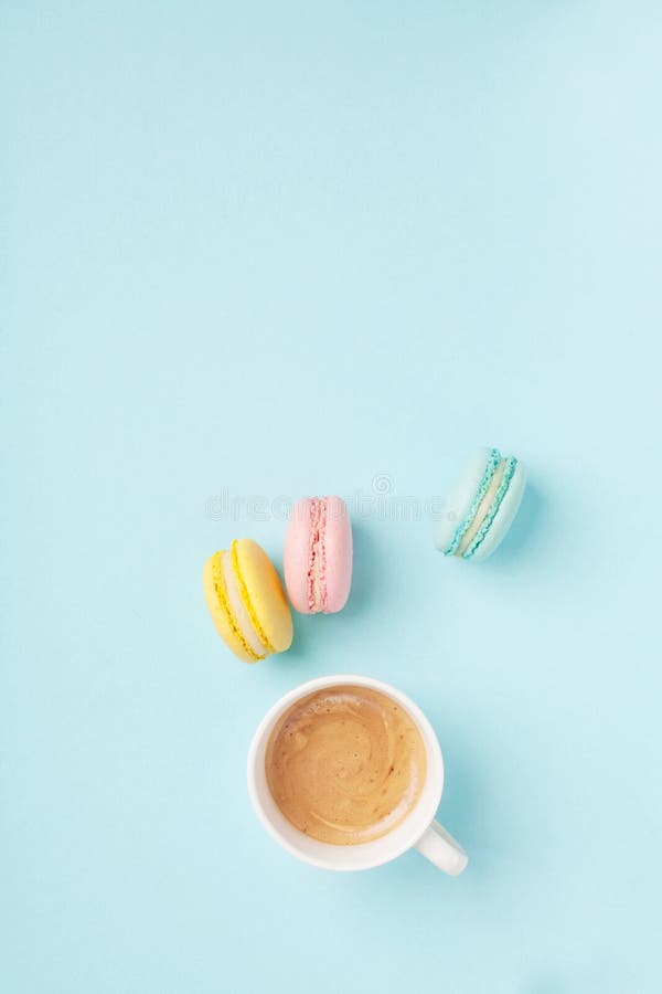 咖啡和五颜六色的macaron在淡色蓝色背景顶视图 舒适早晨早餐时尚舱内甲板位置样式 免版税库存图片 咖啡和五颜六色的macaron在淡色蓝色背景顶视图 舒适早晨早餐时尚舱内甲板位置样式 免版税库存图片