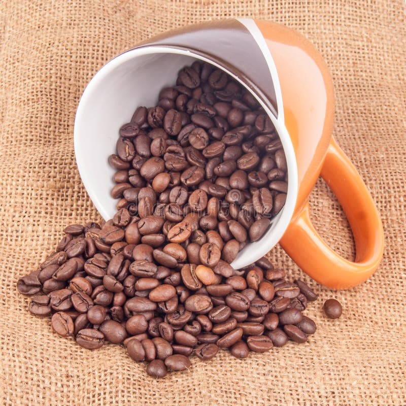 咖啡杯用在帆布的咖啡豆 免版税库存照片
