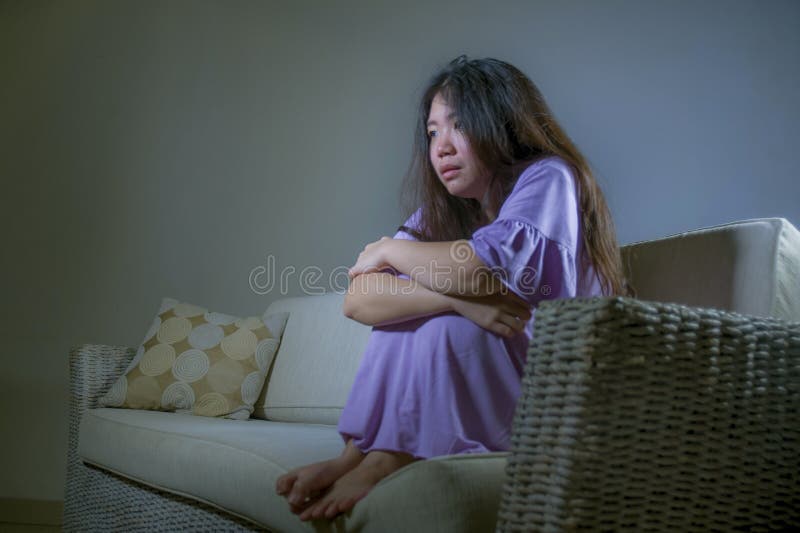 哭泣年轻哀伤和沮丧的亚洲韩国妇女在家沙发的长沙发绝望和无能为力的遭受的忧虑和消沉feeli 图库摄影 哭泣年轻哀伤和沮丧的亚洲韩国妇女在家沙发的长沙发绝望和无能为力的遭受的忧虑和消沉feeli 图库摄影