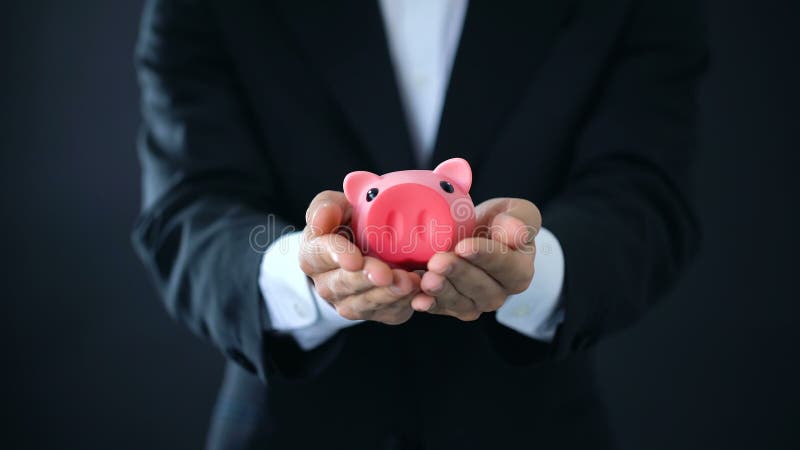 商人在手上的拿着piggybank，公司投资，财政顾问