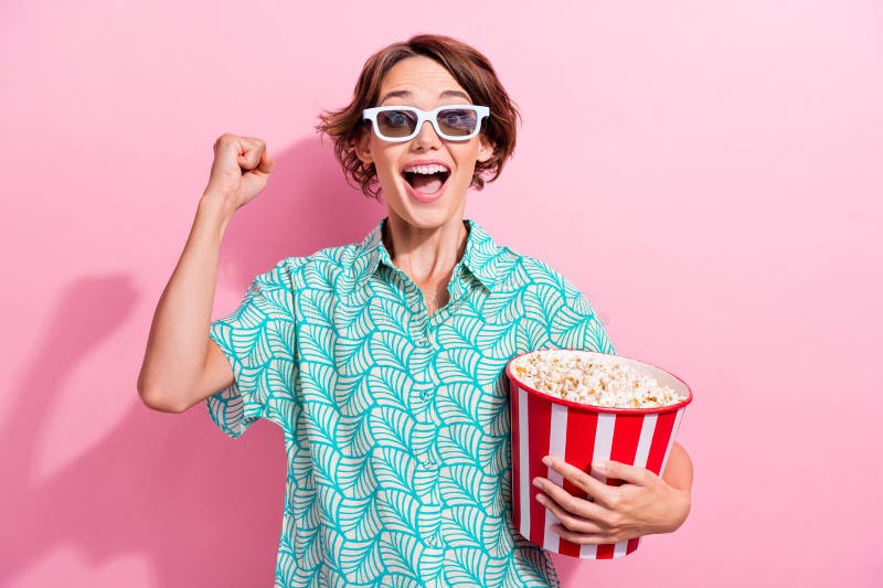 Portrait of overjoyed crazy lady hold popcorn raise fist shout yes hooray watch movie 3d glasses isolated on pink color background. Portrait of overjoyed crazy lady hold popcorn raise fist shout yes hooray watch movie 3d glasses isolated on pink color background.