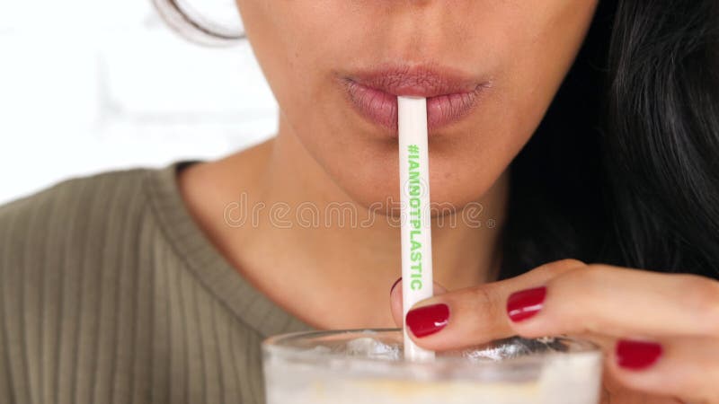 喝与Plactic自由的秸杆的年轻混合的族种女孩被冰的拿铁 我不塑料的Hashtag意味零的废生态行星帮助 股票录像