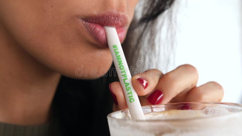 喝与Plactic自由的秸杆的年轻混合的族种女孩被冰的拿铁 我不塑料的Hashtag意味零的废生态行星帮助 股票录像